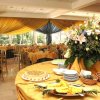 Sala da pranzo elegante con tavoli apparecchiati e grandi composizioni floreali.