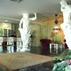 Lobby decorata con statue classiche e arredamento lussuoso.