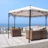 Gazebo in metallo con sedie in vimini su una piattaforma di piastrelle con vista mare.