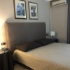 Camera da letto con testata imbottita, lenzuola beige, e aria condizionata sopra.