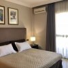 Camera da letto con letto matrimoniale, lampada da tavolo, e due quadri sopra il letto.