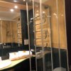 Bagno con doccia, lavandino e asciugamani piegati su un piano verde.