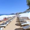Spiaggia con lettini e ombrelloni bianchi.