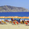 File di ombrelloni e sedie sulla spiaggia.