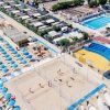 Spiaggia con ombrelloni blu e campi da beach volley.