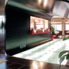 Reception moderna con dettagli in acciaio e zona lounge.