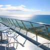 Tavolini su una terrazza con vista mare.