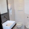 Un piccolo bagno moderno con lavabo, wc, bidet e asciugacapelli.