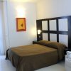 Una camera da letto con letto matrimoniale, parete con testata scura e due applique.