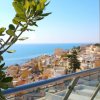 Balcone con vista su case colorate e mare.