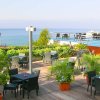 Terrazza con tavoli, sedie e vista mare.