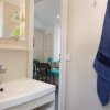 Lavabo bianco con asciugamano blu appeso.
