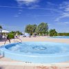 Una vasca idromassaggio vicino a una piscina all'aperto.