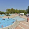 Piscina con persone che nuotano e prendono il sole.