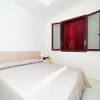 Camera da letto con letto matrimoniale, finestra con persiane rosse.