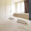 Camera da letto con letto matrimoniale, due asciugamani piegati, armadio blu e finestra.