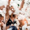 Persone felici immerse in una festa di schiuma.