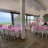 Sala evento con tovaglie rosa e vista sul mare.