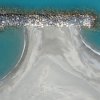 Veduta aerea di una spiaggia con diga di rocce.