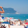 Bagnina osserva la spiaggia con binocolo.