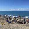 Spiaggia con ombrelloni a righe bianche e blu.