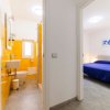 Bagno giallo e camera da letto con letto blu.