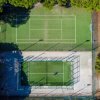 Vista aerea di campi da tennis verdi e recintati.