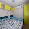 Camera con due letti e armadio giallo.