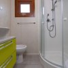 Bagno moderno con doccia e mobile verde lime.