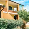 Edificio giallo con balcone e vegetazione.