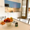 Cucina con pensili blu e tavolo con frutta.