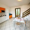 Cucina e sala da pranzo con scala e tavolo apparecchiato.