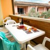 Balcone con tavolo, sedie bianche e bevande.