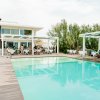Piscina ampia con ristorante sullo sfondo.