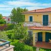 Casa gialla con tetto rosso e giardino.