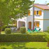 Casa con sedie a sdraio in un giardino verde.