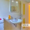 Bagno con lavabo, specchio e asciugamani decorati con fiori.