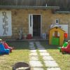 Bambini giocano all'aperto con altalene di plastica.