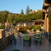 Terrazza di un ristorante all'aperto con sedie verdi e tavoli, vicino alla spiaggia.