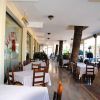 Veranda ristorante con tavoli apparecchiati e palme che attraversano il soffitto.