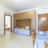 Camera con letto integrato nell'armadio, tavolo apparecchiato e TV su supporto in legno.
