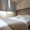 Camera da letto con letto matrimoniale e tende grigie.