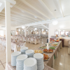 Sala da pranzo con un tavolo buffet ricco di piatti pronti e piatti impilati.