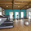 Palestra con attrezzature fitness, tapis roulant e pareti in legno.