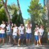 Gruppo di persone in abiti casual pose giocose su un sentiero alberato.