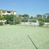 Campo di calcio a 5 con erba sintetica e porta bianca.