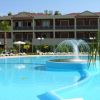 Piscina con fontana centrale, ombrelloni e hotel a più piani sullo sfondo.
