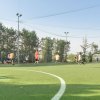 Partita di calcio su un campo all'aperto circondato da alberi.