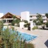 Resort con piscina blu e giardino curato.