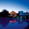 Resort illuminato al crepuscolo con riflessi in piscina.